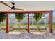 Screened-in patio with ceiling fan, featuring unique tiled flooring and tropical landscaping at 3730 Sail Dr, New Port Richey, FL 34652