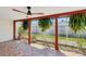 Screened-in patio with tiled flooring, ceiling fan, and view of the landscaped backyard at 3730 Sail Dr, New Port Richey, FL 34652