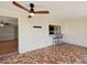 Enclosed patio features unique tile flooring, a ceiling fan, and a bar-style window looking into the kitchen at 3730 Sail Dr, New Port Richey, FL 34652
