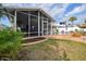 Backyard featuring a screened lanai, pool, and well-maintained lawn, ideal for outdoor enjoyment at 4048 Orient Dr, Hernando Beach, FL 34607