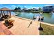 Paver patio with canal views, featuring a dock, outdoor seating, and a charming gazebo at 4048 Orient Dr, Hernando Beach, FL 34607