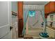 Bright bathroom featuring a tub with shower, decorative curtains, and stained glass window adding charm at 4048 Orient Dr, Hernando Beach, FL 34607