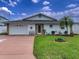 Inviting single-story home with a well-manicured lawn, attached garage and stone accented entryway at 4048 Orient Dr, Hernando Beach, FL 34607