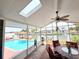 Bright sunroom featuring a ceiling fan, skylight, outdoor seating, and a view of the pool and waterway at 4048 Orient Dr, Hernando Beach, FL 34607