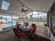 The sunroom features a glass table with seating for four and views of the pool and waterfront at 4048 Orient Dr, Hernando Beach, FL 34607