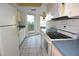 Bright kitchen with white cabinets and appliances, featuring tiled floors and a sunlit window area at 4707 Wallingford Ct # 4707, New Port Richey, FL 34655