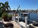 A waterfront backyard featuring a boat lift, kayaks, and a patio with views of the canal at 4903 Forecastle Dr, New Port Richey, FL 34652