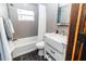 Modern bathroom features gray tiled walls, a white vanity, and shower/tub combo at 506 8Th Ave Sw, Largo, FL 33770