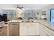 The kitchen island features a stainless steel dishwasher and a great view of the living room at 5434 Glover Dr, Weeki Wachee, FL 34607