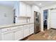 Kitchen featuring white cabinets, stainless steel refrigerator, and granite countertops at 5434 Glover Dr, Weeki Wachee, FL 34607