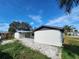 Low angle daytime side exterior of white house with dark grey trim and stone-pattern driveway at 6034 Seabreeze Dr, Port Richey, FL 34668