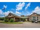 Exterior shot of clubhouse featuring covered entrance, golf carts, and beautifully landscaped surroundings at 6152 Clark Lake Dr, New Port Richey, FL 34655