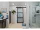 Bathroom with frosted glass barn door, a marble-look shower and dark vanity at 6555 Redbay Dr, Brooksville, FL 34602