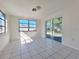 Bright bedroom featuring tile floors, large window, and sliding glass door at 7421 San Miguel Dr, Port Richey, FL 34668