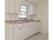 Clean kitchen featuring white cabinetry, modern sink, and functional appliances at 7421 San Miguel Dr, Port Richey, FL 34668