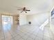 Bright living room with large windows and tile floors, leading into the kitchen at 7421 San Miguel Dr, Port Richey, FL 34668