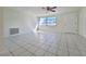 Bright, spacious living room with tile floors, a ceiling fan, and a window at 7421 San Miguel Dr, Port Richey, FL 34668