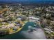 Community aerial view featuring a pool, tennis court, lake, and dock with gazebo amidst lush greenery at 8110 Bismark Ct, Port Richey, FL 34668