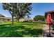 Green backyard lawn with mature trees, providing a serene outdoor space at 8110 Bismark Ct, Port Richey, FL 34668