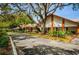 The Timber Oaks community building is surrounded by lush landscaping and trees in this daytime shot at 8110 Bismark Ct, Port Richey, FL 34668