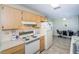 Bright kitchen featuring standard appliances, wood cabinetry, and an adjacent dining area at 8110 Bismark Ct, Port Richey, FL 34668