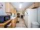 Efficient kitchen layout with light-colored cabinets, essential appliances, and connection to the dining space at 8110 Bismark Ct, Port Richey, FL 34668