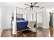 Bright main bedroom with a four-poster bed, hardwood floors, ceiling fan, and ample natural light at 836 Village Dr, Brooksville, FL 34601