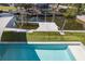 Beautiful backyard featuring a sparkling pool, turf lawn, boat dock, and waterfront access for outdoor enjoyment at 8401 Carolyn Dr, Port Richey, FL 34668