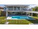 Beautiful backyard featuring a sparkling pool, turf lawn, outdoor kitchen, and waterfront views at 8401 Carolyn Dr, Port Richey, FL 34668
