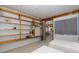 This bedroom contains two twin beds and wooden storage shelves with a view into the next room at 8401 Carolyn Dr, Port Richey, FL 34668
