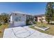 Charming waterfront home featuring a two-car garage, a basketball hoop, a well-manicured lawn, and lush landscaping at 8401 Carolyn Dr, Port Richey, FL 34668