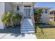 Beautifully landscaped home featuring a modern front door, lush tropical landscaping, and an extended driveway at 8401 Carolyn Dr, Port Richey, FL 34668