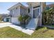 Inviting home entrance with a stylish front door, tropical landscaping, and modern railings at 8401 Carolyn Dr, Port Richey, FL 34668