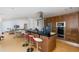 Open concept kitchen with a large center island featuring bar stools, stainless appliances, and wood cabinetry at 8401 Carolyn Dr, Port Richey, FL 34668
