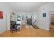 Bright, airy living room featuring a white desk, shelves, and staircase with a modern chandelier at 8401 Carolyn Dr, Port Richey, FL 34668