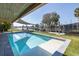 Beautiful covered pool with clear water and lush landscaping overlooking the canal at 8401 Carolyn Dr, Port Richey, FL 34668