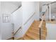 Staircase with contemporary design featuring light wood stairs, stainless steel cable railing, and natural light at 8401 Carolyn Dr, Port Richey, FL 34668