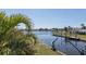Picturesque waterfront view showcasing lush landscaping and a private boat dock and lift system at 8401 Carolyn Dr, Port Richey, FL 34668