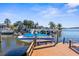Boat on a lift at the private dock behind the house with palm trees at 8408 Damen Ln, Port Richey, FL 34668