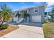 Charming home with two-car garage, white stairs leading to the entrance, and lush green lawn at 8408 Damen Ln, Port Richey, FL 34668