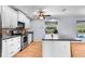 Well-lit kitchen featuring white cabinetry, stainless steel appliances, and a functional island at 8408 Damen Ln, Port Richey, FL 34668