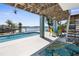 Spacious covered patio area featuring a waterfront pool, perfect for outdoor entertainment and relaxation at 8408 Damen Ln, Port Richey, FL 34668