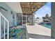 Cozy covered patio adjacent to a sparkling pool with seamless access to indoor/outdoor living at 8408 Damen Ln, Port Richey, FL 34668