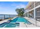 Inviting pool and spa area on the waterfront with covered outdoor seating and dock access at 8408 Damen Ln, Port Richey, FL 34668