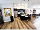 Open kitchen featuring stainless steel appliances, modern black cabinetry, a breakfast bar, and an adjacent dining area at 9089 Dupont Ave, Spring Hill, FL 34608