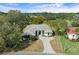Aerial view of the home featuring a paved driveway and mature trees, highlighting its curb appeal at 9397 Merriweather Dr, Weeki Wachee, FL 34613