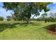 The manicured backyard features mature trees and lush green grass at 9397 Merriweather Dr, Weeki Wachee, FL 34613