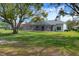 A screened lanai attached to the rear of the home overlooks a meticulously maintained backyard with an expansive green lawn at 9397 Merriweather Dr, Weeki Wachee, FL 34613