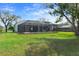 View of the large screened-in lanai and spacious backyard, perfect for outdoor living and entertaining at 9397 Merriweather Dr, Weeki Wachee, FL 34613