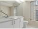 Bright bathroom with a vanity, mirror, toilet, and window at 9397 Merriweather Dr, Weeki Wachee, FL 34613